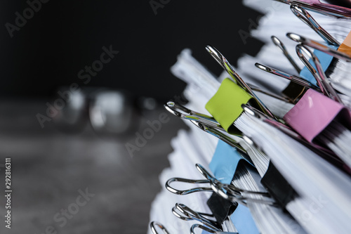 Stack of documents with binder clips on table, closeup view. Space for text photo