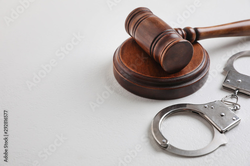Tableau sur toile Gavel and handcuffs on white table, space for text. Criminal law