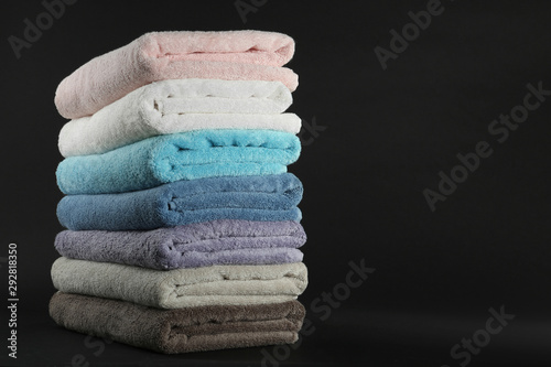 Different fresh soft terry towels on dark background
