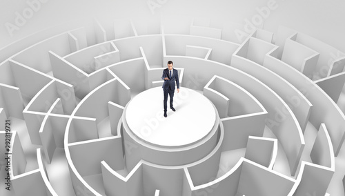 Businessman standing on the top a maze and looking through