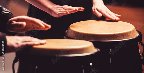 The musician plays the bongo. Close up of musician hand playing bongos drums. Afro Cuba, rum, drummer, fingers, hand, hit. Drum. Hands of a musician playing on bongs.