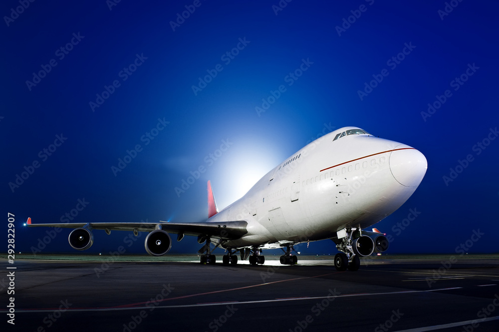 The plane stands at the airport at night