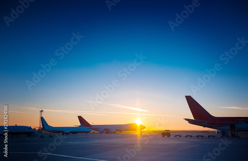 Many planes are standing at the airport at a beautiful sunset.