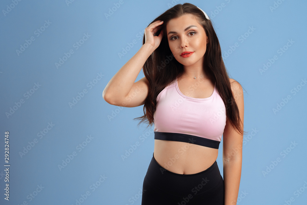 portrait of a young fitness woman in sportswear posing in studio