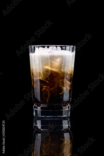 classic white Russian cocktail with reflection on a dark background