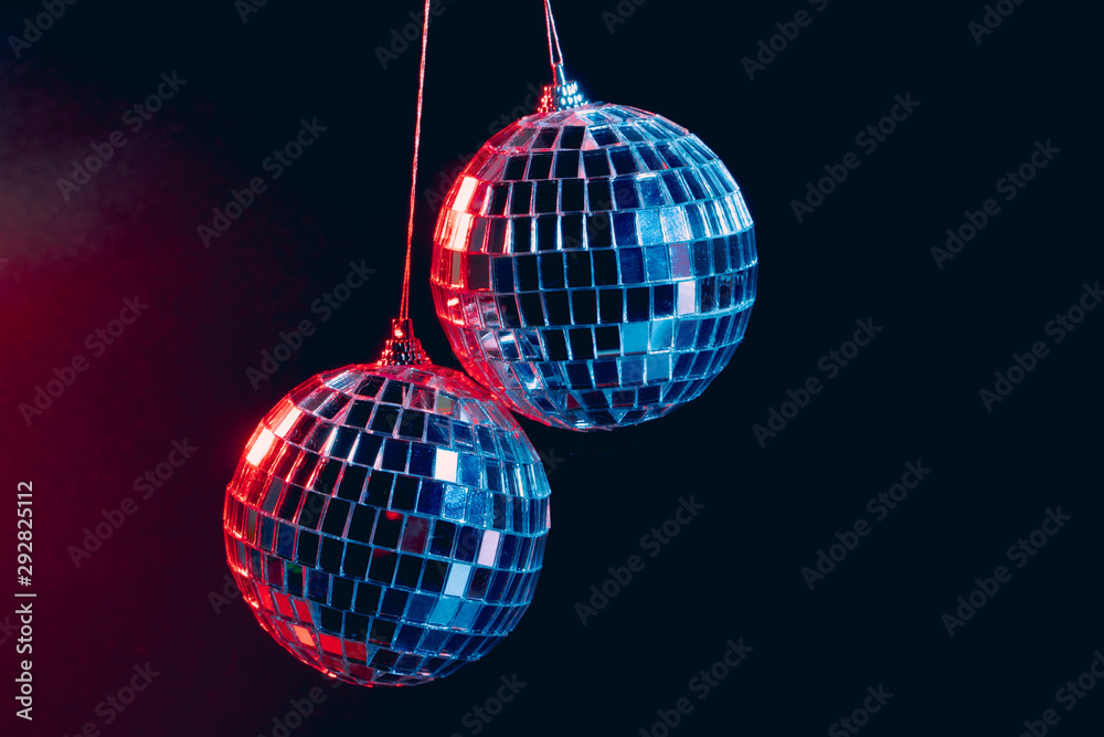 Obraz premium Sparkling disco balls hanging in the air against black background