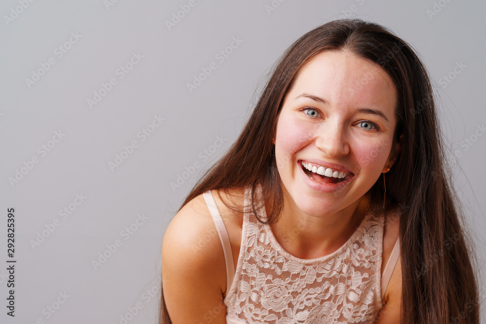 Beautiful woman teenager posing over a grey background. Beautiful woman teenager posing over a grey background.