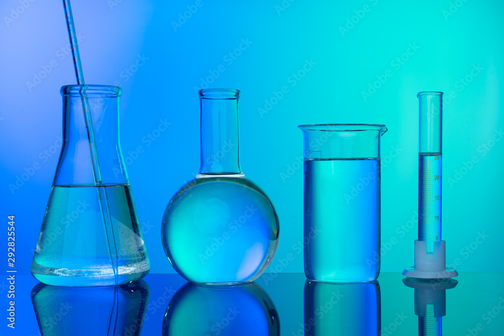 Row of test tubes with liquids on blue and green toned background Row of test tubes with liquids on blue and green toned background