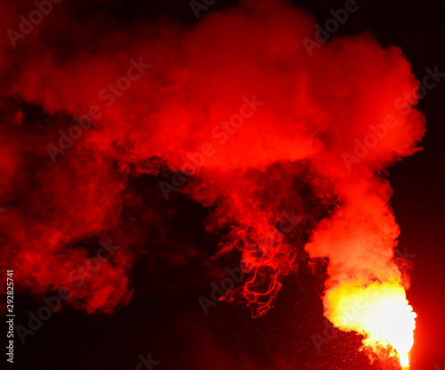 Red smoke burns at night as a background