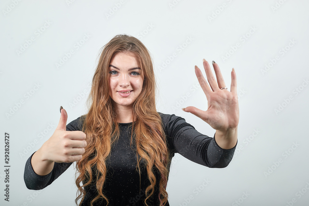 girl brown haired in black dress over isolated white background shows emotions girl brown haired in black dress over isolated white background shows emotions