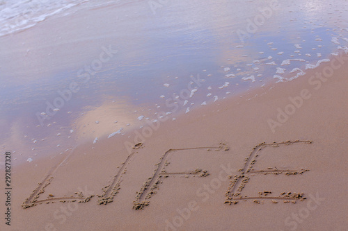 The inscription  Life  on the sand of the seashore. The concept of lifestyle  thirst for life  happiness  freedom  enjoyment of life.