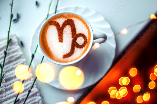A cup of cappuccino coffee with a zodiac sign