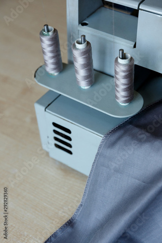 Still life. Sewing supplies. Overlock threads and gray fabric photo