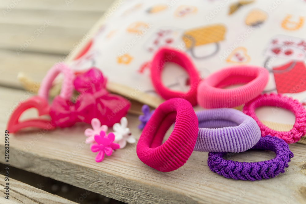 Different types and colour of hair bands, pins and clips on wooden  background. Selective focus. Stock Photo | Adobe Stock