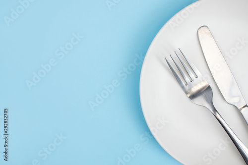 Top view plate with a spoon on the blue background. Close up. With copy space.