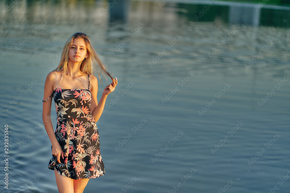 teen girl walks along the beach in a short summer dress. copy
