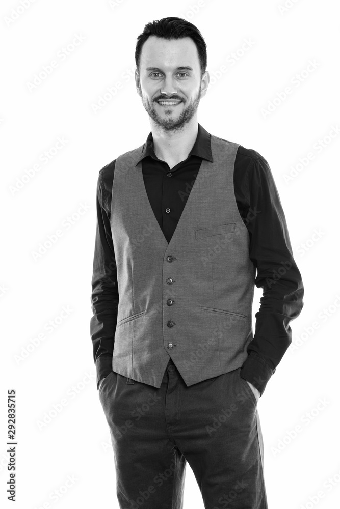 Fototapeta premium Studio shot of happy young man smiling while standing and wearing vest