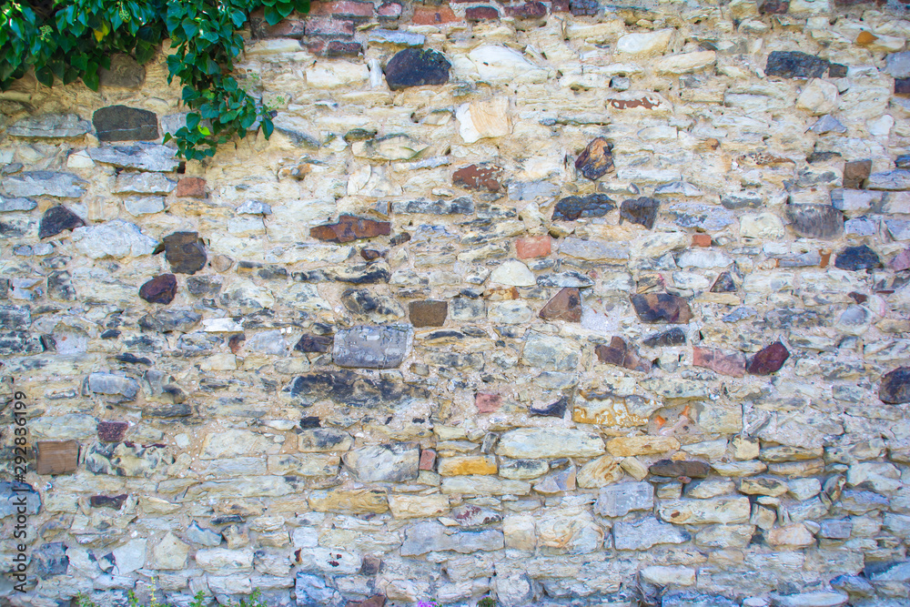Old stone wall partially repaired with brickwork with climbing plants Stock Photo Adobe Stock