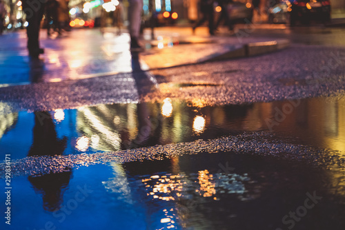 Night street in a big city after rain, night lights, bokeh, blur and reflection in a puddle