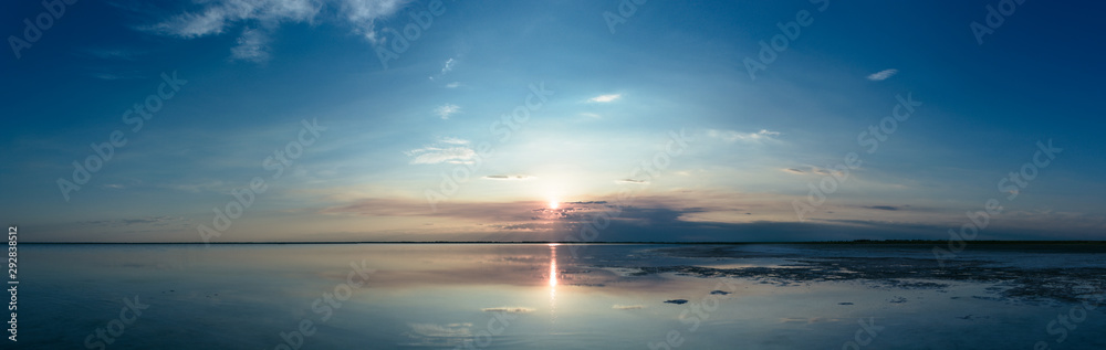 The serene landscape of the lake and the sky reflected in the water. Panorama