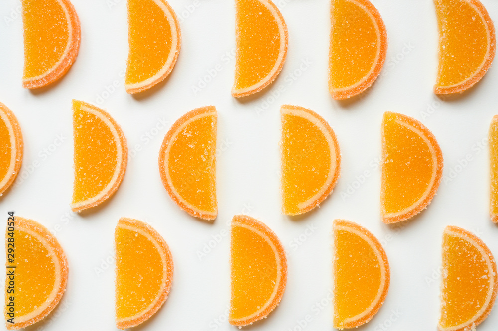 citrus jelly slices in sugar. marmalade slices of oranges and laid rows on a white background. top view citrus jelly slices in sugar. marmalade slices of oranges and laid rows on a white background. top view