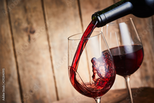 Foto Red wine being poured into an elegant wineglass