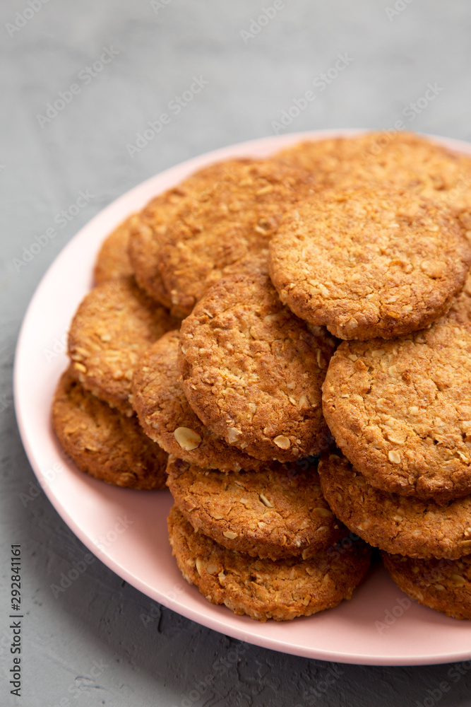 Cereal cookies on a pink plate on a gray surface, low angle view. Close-up. Cereal cookies on a pink plate on a gray surface, low angle view. Close-up.
