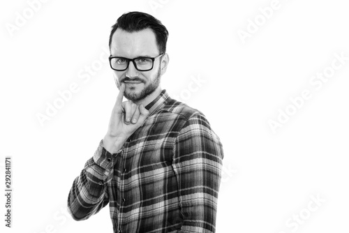 Studio shot of young man with pinky finger on mouth