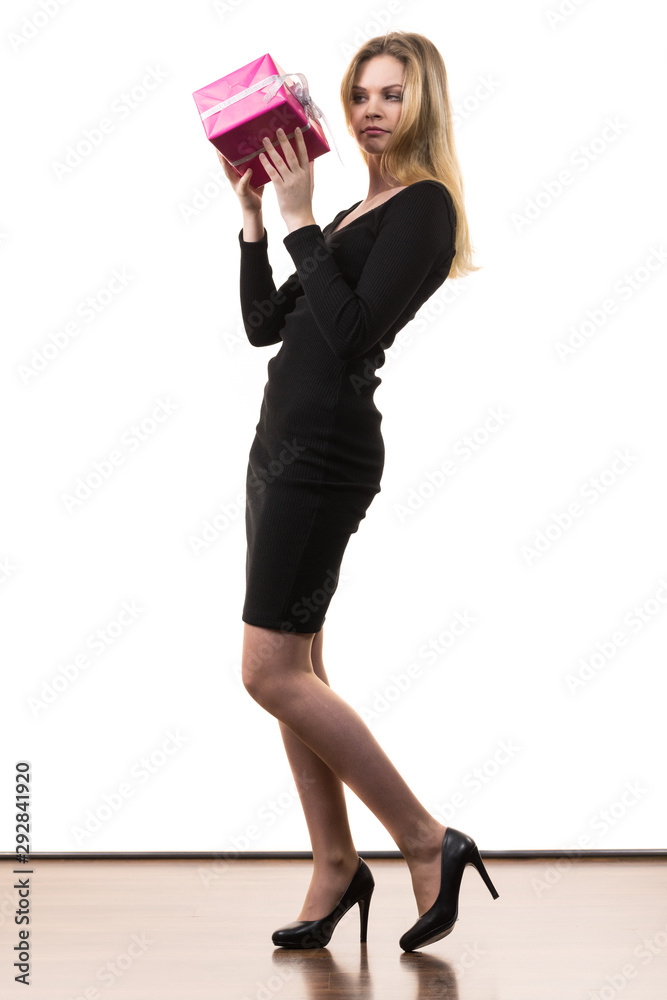 Girl holding present shaking pink gift box Girl holding present shaking pink gift box