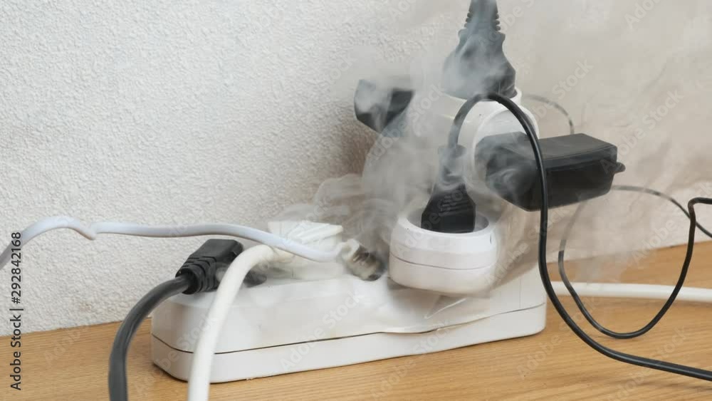 Fire in power strip with electrical plugs on table indoors. concept of occurrence of fire.