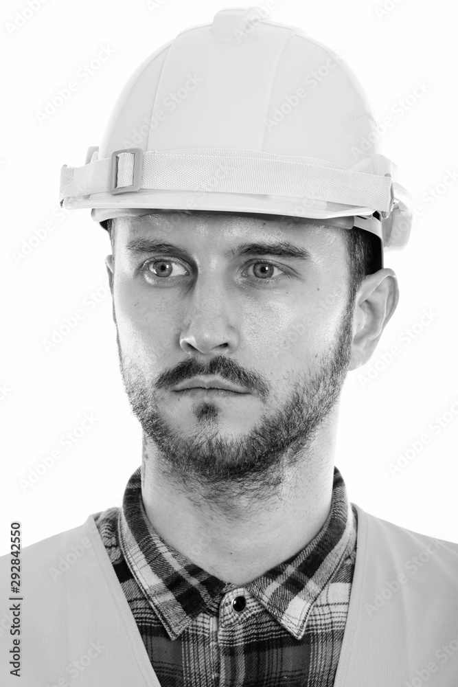 Face of young man construction worker thinking while looking at distance