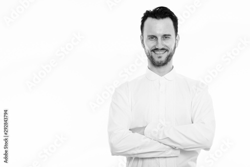 Studio shot of happy young man smiling with arms crossed