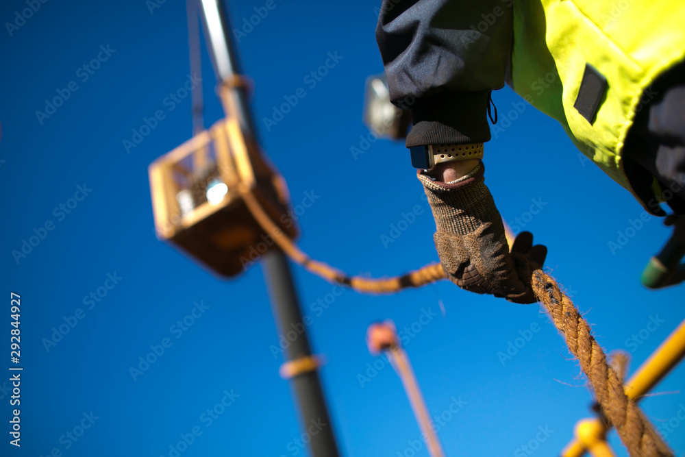 Rope access rigger worker commencing high risk job wearing heavy duty glove  holding a safety tag