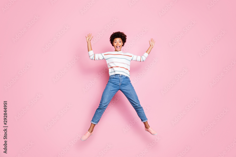 Full length body size photo of ecstatic overjoyed beautiful attractive cute nice black lady rejoicing with jumping up wearing jeans denim shaping star in striped sweater isolated pastel color Full length body size photo of ecstatic overjoyed beautiful attractive cute nice black lady rejoicing with jumping up wearing jeans denim shaping star in striped sweater isolated pastel color