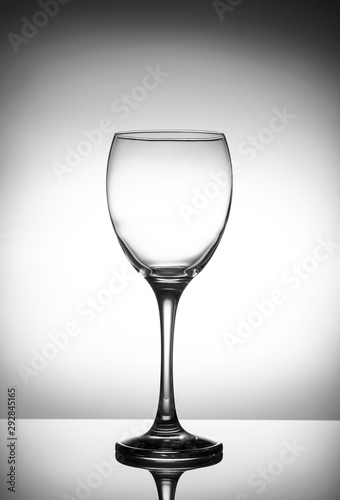 Transparent crystal wineglass on a light gradient background close-up
