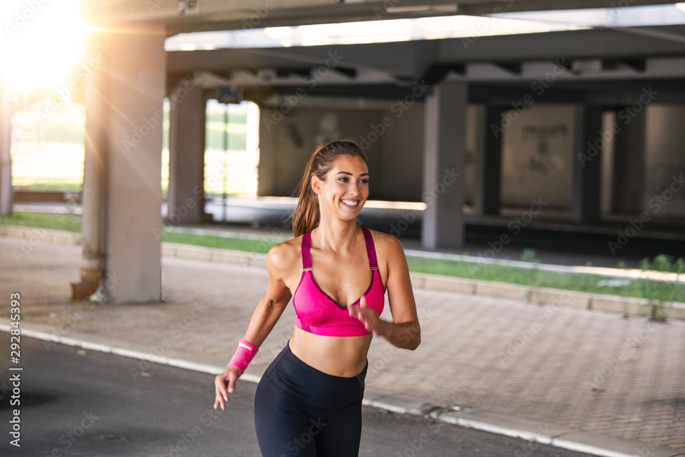Young woman with fit body running Female model in sportswear exercising outdoors.Woman Doing Workout Exercises On Street. Young woman with fit body running Female model in sportswear exercising outdoors.Woman Doing Workout Exercises On Street.