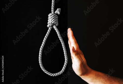 Slika na platnu Hand near the noose on black background