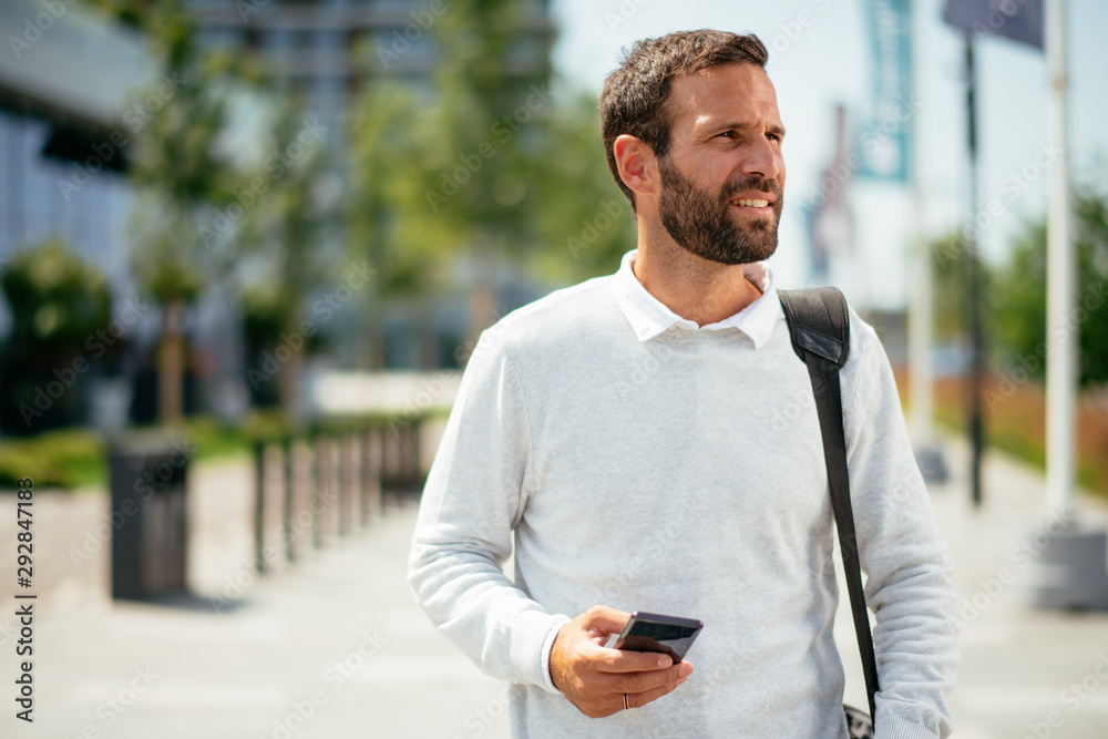 Young man walking and typing message