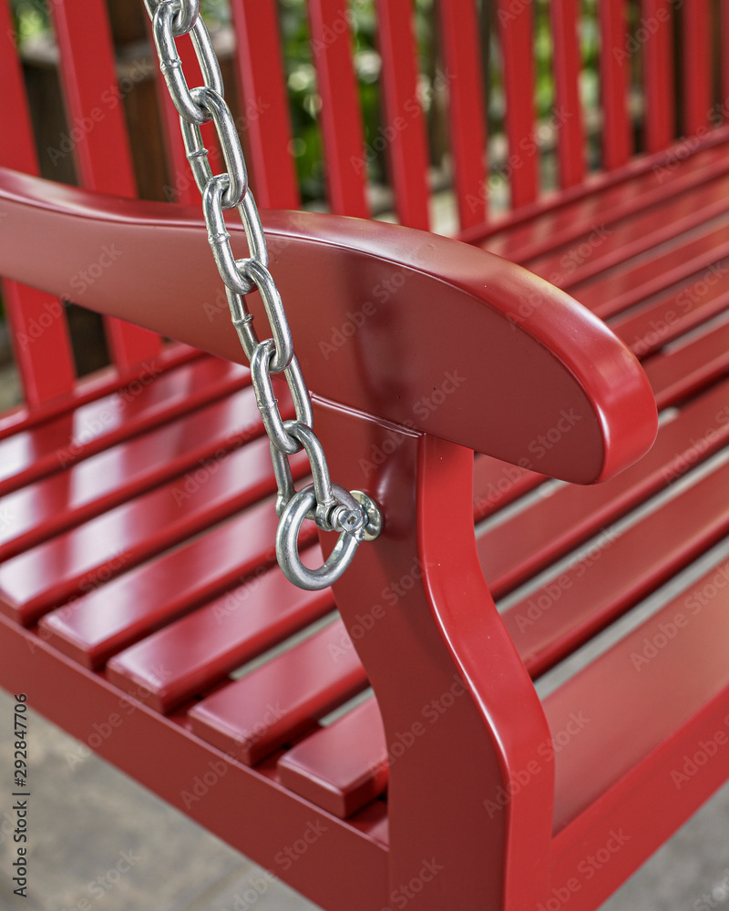 The detail of red wood swing in the backyard.