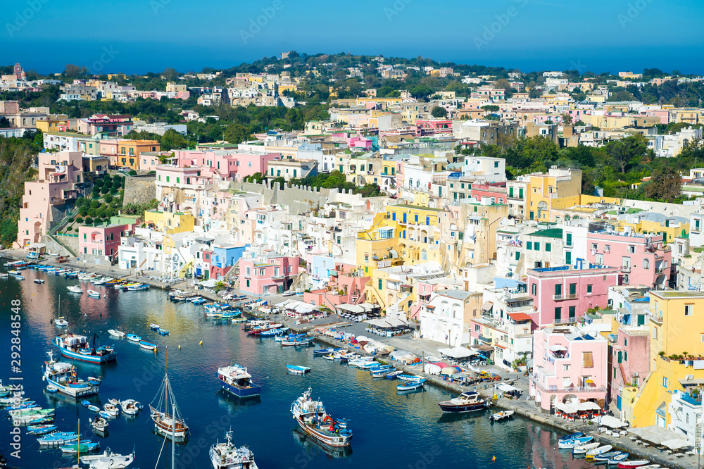 Bright scenic overlook view of the colorful traditional hillside architecture of Corricella harbour on the island of Procida, Italy