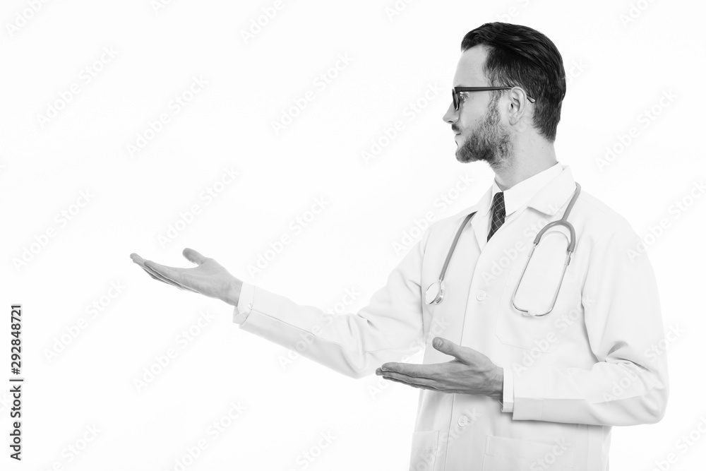 Profile view of young man doctor showing something Profile view of young man doctor showing something