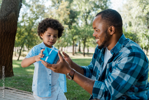 happy of african american father and son holding blue gift box © LIGHTFIELD STUDIOS