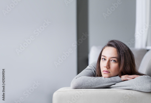 Fotografie Depressed young woman on sofa at home.