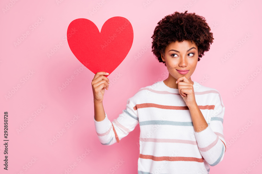photo of stylish trendy cute charming sly looking suspiciously black millennial thinking on gifting postcard heart holding with her hand wearing sweater white striped isolated pastel color background photo of stylish trendy cute charming sly looking suspiciously black millennial thinking on gifting postcard heart holding with her hand wearing sweater white striped isolated pastel color background