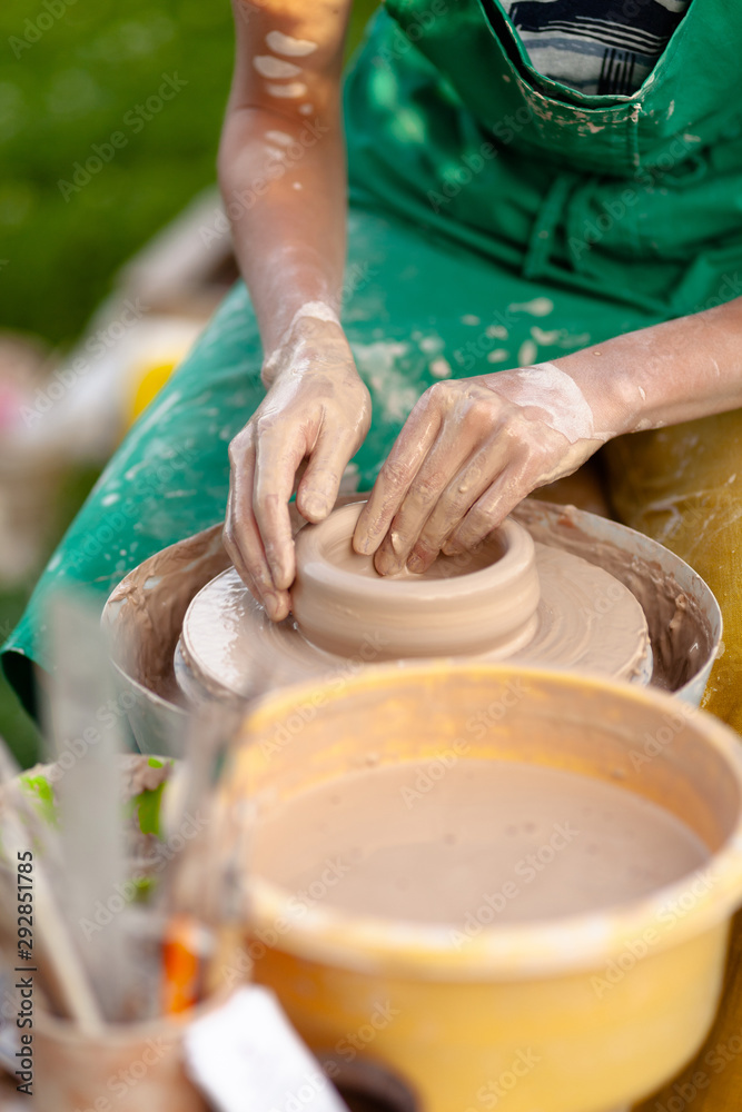 Hand craft making pottery on wheel. Female hands mold ceramic plate from clay (pot). Hand craft making pottery on wheel. Female hands mold ceramic plate from clay (pot).