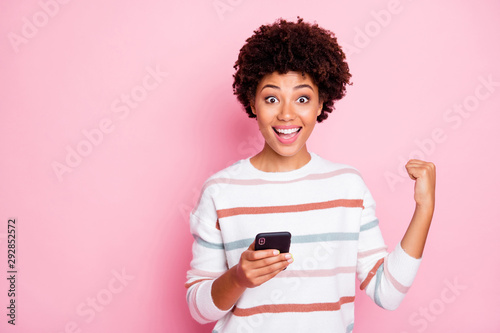 Photo of stylish cheerful cute nice sweet rejoicing excited crazy girl having received positive message expressing ecstatic emotions with her face isolated over pink pastel color background