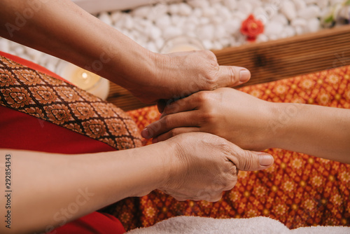 cropped view of masseur doing hand massage to woman in spa salon