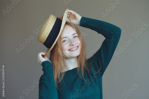 pretty young redhead woman having fun at home, wearing straw hat, posing, having fun photo