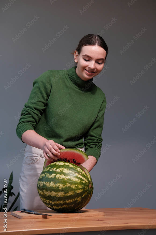 girl cuts a watermelon a knife on a board girl cuts a watermelon a knife on a board