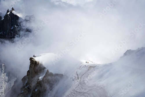 Snowy Amountsin peaks in alps with small unrecognizable figures of alpinists